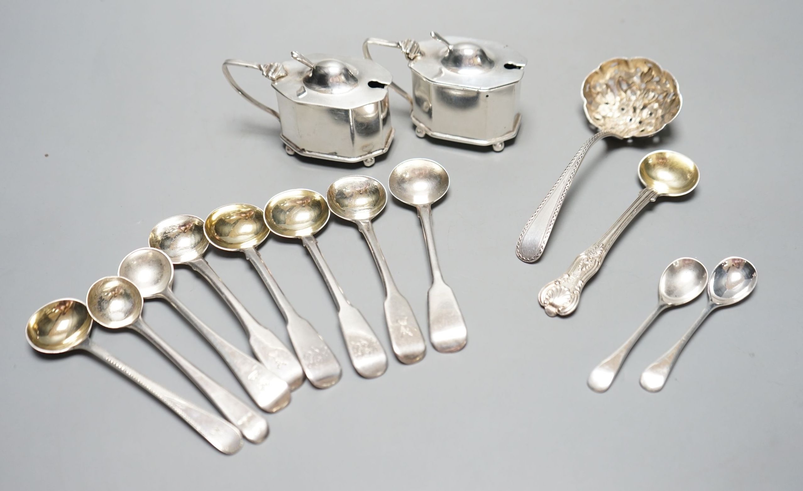 Seven assorted Georgian silver mustard ladles , a strainer, a pair of silver mustard pots and four spoons.